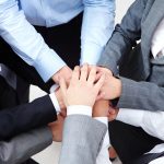 Image of business people hands on top of each other symbolizing support and power